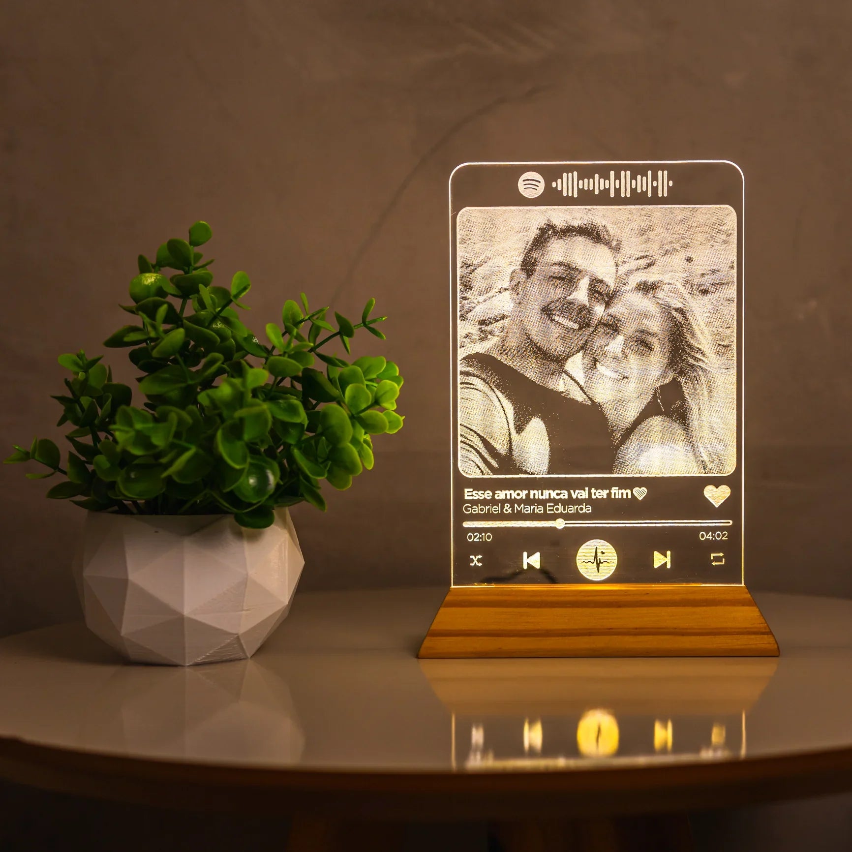 Luminária personalizada Spotify com foto de casal e vaso de planta em mesa de decoração moderna