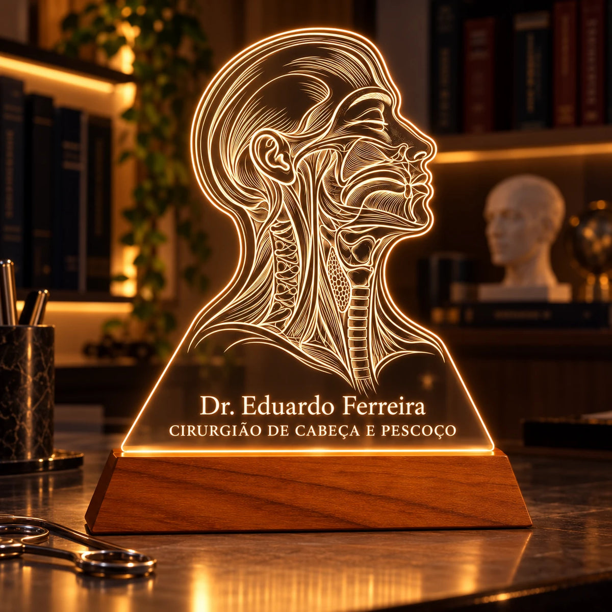 Luminária Cirurgião de Cabeça e Pescoço acesa sobre a mesa de um consultório em penumbra, ao lado de livros e um busto anatômico