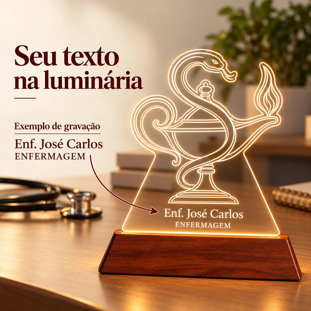 Seu texto na luminária: exemplo de gravação com o nome Enf. José Carlos e a especialidade ENFERMAGEM sob a lamparina com serpente, com seta indicando os textos personalizáveis