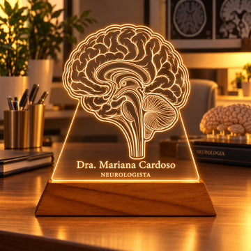 Luminária Neurologista personalizada acesa, com desenho de cérebro em corte e o nome Dra. Mariana Cardoso gravados em acrílico sobre base de madeira