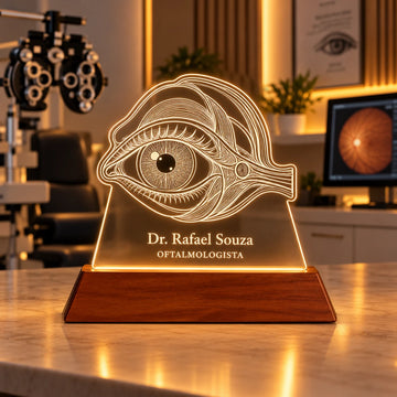 Luminária Oftalmologista personalizada acesa, com desenho de olho anatômico e o nome Dr. Rafael Souza gravados em acrílico sobre base de madeira